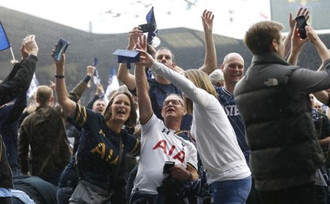 Fans take photographs as the pitch is invaded after the English Premier League soccer match between Tottenham Hotspur and Manchester United at White Hart Lane stadium in London, Sunday, May 14, 2017. It was the last Spurs match at the old stadium, a new stadium is being built on the site. (AP Photo/Frank Augstein)
