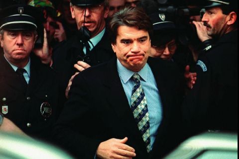Former Olympique Marseille soccer club owner Bernard Tapie grimaces as police officers escort him out of the Douai courthouse, northern France Tuesday Nov.28, 1995, after an appeals court sentenced him to eight months and barred him from office for three years in a soccer bribery scandal. The court said the financially troubled tycoon was guilty of corruption and witness-tampering. Tapie appealed the sentence, and maintains parliamentary immunity from serving in prison. (AP Photo/Thomas Coex)