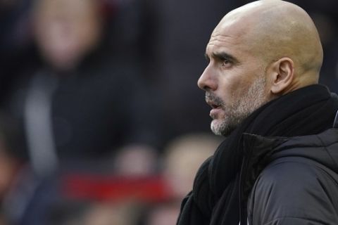 Manchester City's head coach Pep Guardiola watches the English Premier League soccer match between Manchester United and Manchester City at Old Trafford in Manchester, England, Sunday, March 8, 2020. (AP Photo/Dave Thompson)