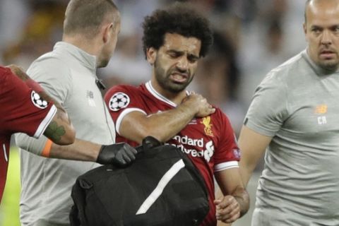 Liverpool's Mohamed Salah grimaces as he leaves after injuring himself during the Champions League Final soccer match between Real Madrid and Liverpool at the Olimpiyskiy Stadium in Kiev, Ukraine, Saturday, May 26, 2018 (AP Photo/Matthias Schrader)