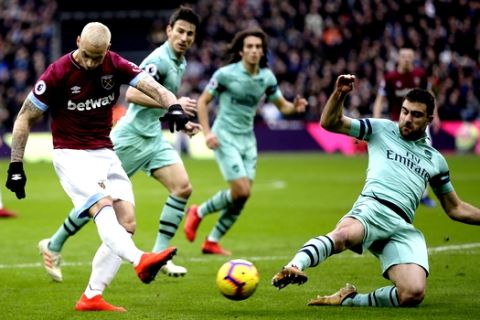 Arsenal's Sokratis Papastathopoulos, right, blocks a shot from West Ham's Marko Arnautovic during the English Premier League soccer match between West Ham United and Arsenal at London Stadium in London, Saturday, Jan. 12, 2019. (AP Photo/Tim Ireland)