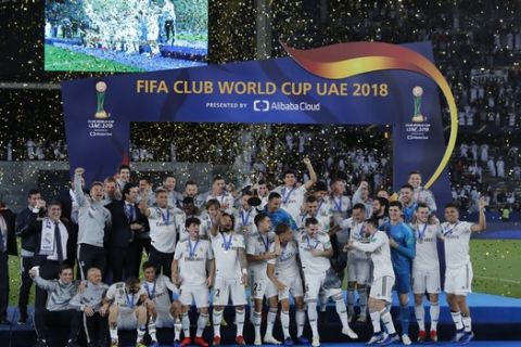 Real Madrid's players celebrate with the trophy after winning the Club World Cup final soccer match between Real Madrid and Al Ain at Zayed Sport City in Abu Dhabi, United Arab Emirates, Saturday, Dec. 22, 2018. (AP Photo/Hassan Ammar)