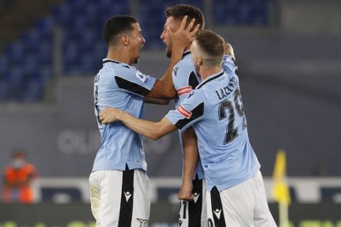 Lazio's Sergej Milinkovic-Savic, center, celebrates after scoring his side's opening goal during a Serie A soccer match between Lazio and Cagliari, at the Rome's Olympic Stadium, in Rome, Italy, Thursday, July 23, 2020. (AP Photo/Riccardo De Luca)