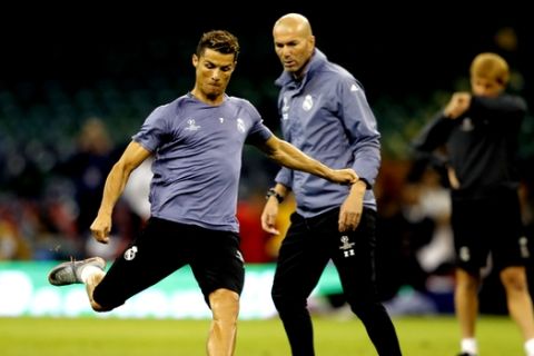 Real Madrid's Cristiano Ronaldo is watched by head coach Zinedine Zidane, right, during a training session at the Millennium Stadium in Cardiff, Wales Friday June 2, 2017. Real Madrid will play Juventus in the final of the Champions League soccer match in Cardiff on Saturday. (AP Photo/Frank Augstein)