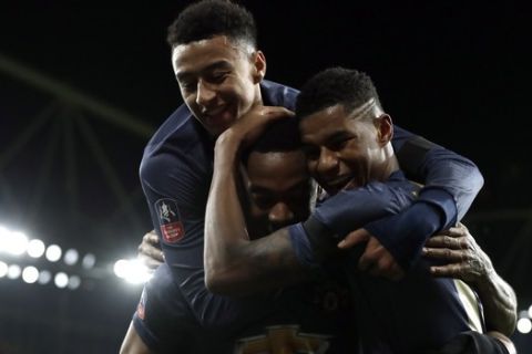 Manchester United's Anthony Martial, center, celebrates with teammates after scoring his side's third goal during the English FA Cup fourth round soccer match between Arsenal and Manchester United at the Emirates stadium in London, Friday, Jan. 25, 2019. (AP Photo/Matt Dunham)