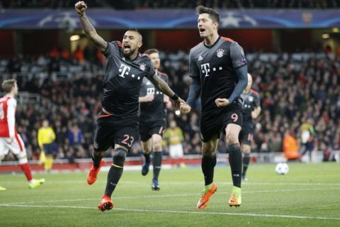 Bayern's Robert Lewandowski celebrates with Arturo Vidal, left, after scoring a penalty during the Champions League round of 16 second leg soccer match between Arsenal and Bayern Munich at the Emirates Stadium in London, Tuesday, March 7, 2017. (AP Photo/Frank Augstein)