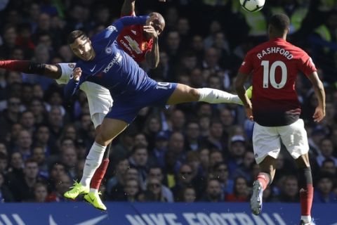 ManU midfielder Ashley Young, rear, and Chelsea's Eden Hazard land after jumping to head the ball during their English Premier League soccer match between Chelsea and Manchester United at Stamford Bridge stadium in London Saturday, Oct. 20, 2018. (AP Photo/Matt Dunham)