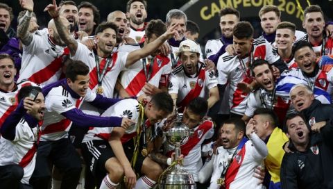 Players of Argentina's River Plate celebrate with the trophy after defeating Argentina's Boca Juniors 3-1 in the Copa Libertadores final soccer match at the Santiago Bernabeu stadium in Madrid, Spain, Sunday, Dec. 9, 2018. (AP Photo/Manu Fernandez)