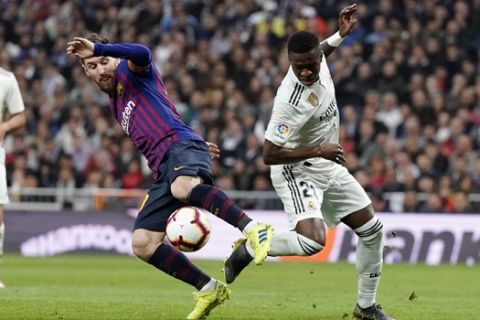 Barcelona forward Lionel Messi, left, and Real forward Vinicius Junior fight for the ball during the Spanish La Liga soccer match between Real Madrid and FC Barcelona at the Bernabeu stadium in Madrid, Saturday, March 2, 2019. (AP Photo/Andrea Comas)