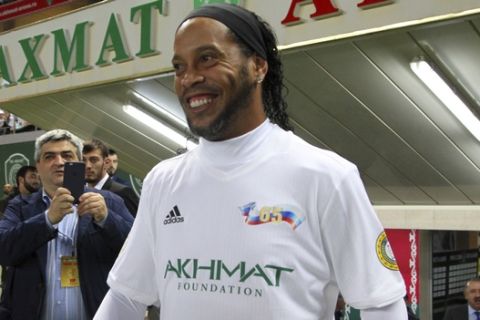 Brazilian soccer star and former FC Barcelona player Ronaldinho, prepares to play in the Chechnya's regional leader Ramzan Kadyrov's team against the Italian former players team in Grozny, Russia, Saturday, Oct. 7, 2017. The Chechen leader, who is fond of sports, particularly soccer and martial arts, enjoys bringing foreign sports stars and other celebrities to Grozny. (AP Photo/Musa Sadulayev)