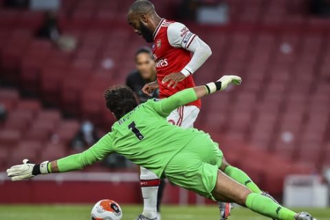 Arsenal's Alexandre Lacazette runs past Liverpool's goalkeeper Alisson before scoring his team first goal during the English Premier League soccer match between Arsenal and Liverpool at the Emirates Stadium in London, England, Wednesday, July 15, 2020. (Glyn Kirk/Pool via AP)