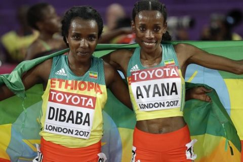 Ethiopia's gold medal winner Almaz Ayana, right, and Ethiopia's silver medal winner Tirunesh Dibaba celebrate after the women's 10,000 meter final during the World Athletics Championships in London Saturday, Aug. 5, 2017. (AP Photo/Matthias Schrader)