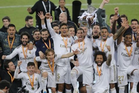 Real Madrid players celebrate with trophy after they beat Atletico Madrid in the Spanish Super Cup Final soccer match at King Abdullah stadium in Jiddah, Saudi Arabia, Monday, Jan. 13, 2020. (AP Photo/Amr Nabil)