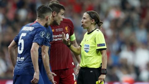 Referee Stephanie Frappart shows a yellow card to Chelsea's Cesar Azpilicueta, 2nd right, during the UEFA Super Cup soccer match between Liverpool and Chelsea, in Besiktas Park, in Istanbul, Wednesday, Aug. 14, 2019. (AP Photo/Thanassis Stavrakis)