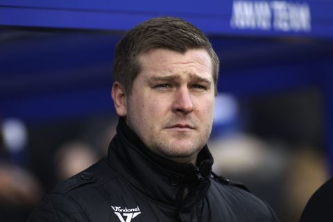 Milton Keynes Dons' manager Karl Robinson looks on from the dugout before the start of their English FA Cup fourth round soccer match against Queens Park Rangers at Loftus Road stadium, London, Saturday, Jan. 26, 2013. (AP Photo/Sang Tan)