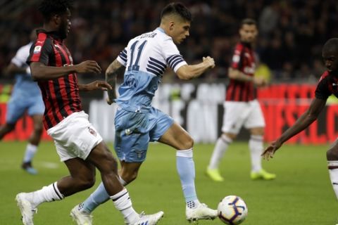Lazio's Joaquin Correa, right, passes the ball as AC Milan's Franck Kessie, left, defends during the Italian Cup, second leg semifinal soccer match between AC Milan and Lazio, at the San Siro stadium, in Milan, Italy, Wednesday, April 24, 2019. (AP Photo/Luca Bruno)