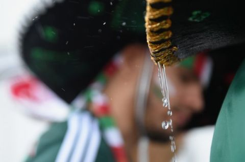 NATAL, BRAZIL - JUNE 13:  Rain water drips off a Mexico fan's sombrero before the 2014 FIFA World Cup Brazil Group A match between Mexico and Cameroon at Estadio das Dunas on June 13, 2014 in Natal, Brazil.  (Photo by Matthias Hangst/Getty Images)