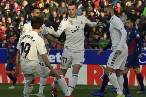 Real Madrid's Gareth Bale, center, celebrates with his fellow team after scoring against SD Huesca during the Spanish La Liga soccer match between Real Madrid and SD Huesca at El Alcoraz stadium, in Huesca, northern Spain, Sunday, Dec. 9, 2018. (AP Photo/Alvaro Barrientos)