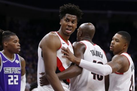 Portland Trail Blazers center Hassan Whiteside, center, has words for referee Josh Tiven, left, after Tiven called him for a foul during the second half of the team's NBA basketball game against the Sacramento Kings in Sacramento, Calif., Friday, Oct. 25, 2019. The Trail Blazers won 122-112. (AP Photo/Rich Pedroncelli)