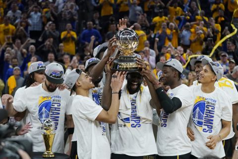 Golden State Warriors players celebrate with the conference championship trophy after defeating the Dallas Mavericks in Game 5 of the NBA basketball playoffs Western Conference finals in San Francisco, Thursday, May 26, 2022. (AP Photo/Jeff Chiu)