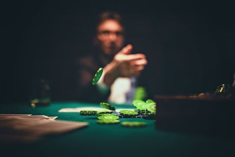 One man, gentlemen playing poker in dark room at night, throwing gambling chips on table.