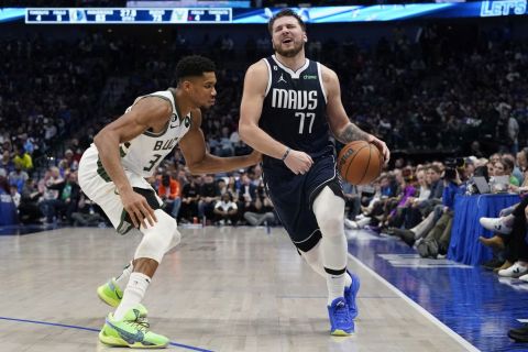 Dallas Mavericks guard Luka Doncic (77) is defended by Milwaukee Bucks forward Giannis Antetokounmpo (34) during the fourth quarter of an NBA basketball game in Dallas, Friday, Dec. 9, 2022. The Bucks won 106-105. (AP Photo/LM Otero)