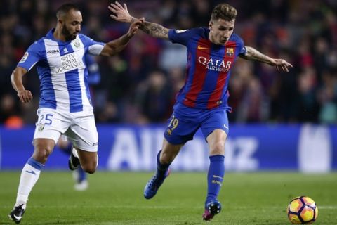 FC Barcelona's Lucas Digne, right, duels for the ball against Leganes' Nabil El Zhar during the Spanish La Liga soccer match between FC Barcelona and Leganes at the Camp Nou stadium in Barcelona, Spain, Sunday, Feb. 19, 2017. (AP Photo/Manu Fernandez)