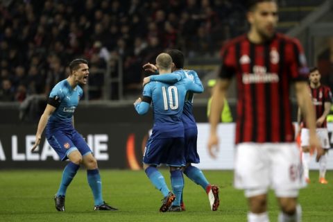 Arsenal's Henrikh Mkhitaryan celebrates with teammates after scoring his side's opening goal during the Europa League round of 16 first-leg soccer match between AC Milan and Arsenal, at the Milan San Siro Stadium, Italy, Thursday, March 8, 2018. (AP Photo/Luca Bruno)