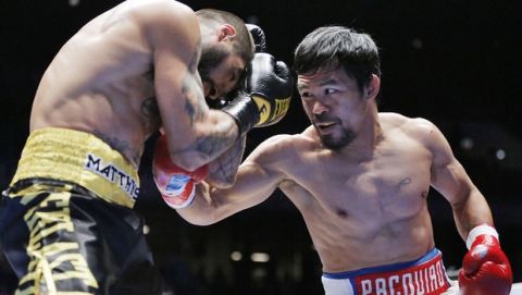 Manny Pacquiao of the Philippines, right, strikes Lucas Matthysse of Argentina during their WBA World welterweight title bout in Kuala Lumpur, Malaysia, Sunday, July 15, 2018. Pacquiao won the WBA welterweight world title after a technical knockout in round seven. (AP Photo/Yam G-Jun)