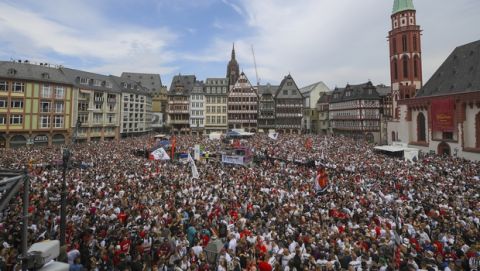Fans of Eintracht Frankfurt soccer club crowd at Roemerberg square in Frankfurt, Germany, Sunday, May 20, 2018 to celebrate their team. Frankfurt coach Niko Kovac stunned his future employer by leading Eintracht Frankfurt to a 3-1 win over Bayern Munich in the German Cup final on Saturday in Berlin. (Andreas Arnold/Pool Photo via AP)