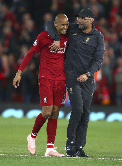 Liverpool's coach Juergen Klopp hugs Liverpool's Fabinho after the Champions League Group C soccer match between Liverpool and Paris-Saint-Germain at Anfield stadium in Liverpool, England, Tuesday, Sept. 18, 2018. Liverpool won the match 3-2. (AP Photo/Dave Thompson)