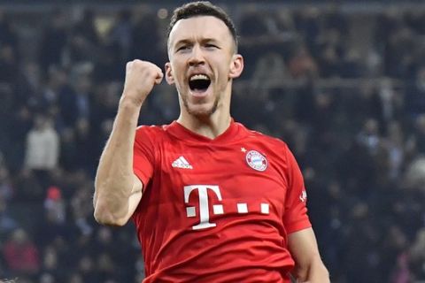 Bayern's Ivan Perisic, top, celebrates after scoring his side's first goal during the German Bundesliga soccer match between Borussia Moenchengladbach and Bayern Munich at the Borussia Park in Moenchengladbach, Germany, Saturday, Dec. 7, 2019. (AP Photo/Martin Meissner)