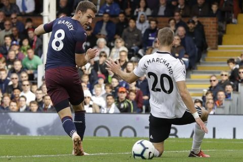Arsenal's Aaron Ramsey, left, scores his side's third goal during the English Premier League soccer match between Fulham and Arsenal at Craven Cottage stadium in London, Sunday, Oct. 7, 2018. (AP Photo/Kirsty Wigglesworth)