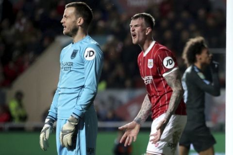 Bristol City's Aden Flint, centre, and goalkeeper Luke Steele look dejected after Manchester City's Leroy Sane celebrates scoring his side's first goal of the game during the English League Cup semi final, second leg match at Ashton Gate, Bristol, England, Tuesday, Jan. 23, 2018. (Nick Potts/PA via AP)