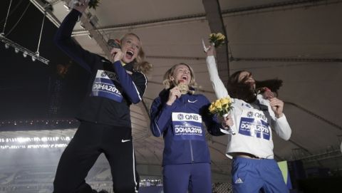 Medalists in the women's pole vault Anzhelika Sidorova, who participates as a neutral athlete, gold, center, Sandi Morris of the United States, silver, left, and Katerina Stefanidi of Greece, bronze, celebrate during the medal ceremony at the World Athletics Championships in Doha, Qatar, Monday, Sept. 30, 2019. (AP Photo/Nariman El-Mofty)