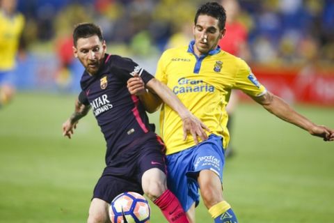 FC Barcelona's Leo Messi, left, duels for the ball against Las Palma's Pedro Bigas during a Spanish La Liga soccer match at the Gran Canaria stadium in Las Palmas, Spain's Canary islands, Sunday May 14, 2017. (AP Photo/Lucas de Leon)