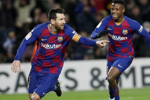 Barcelona's Lionel Messi, left, celebrates with Ansu Fati after scoring the opening goal during a Spanish La Liga soccer match between Barcelona and Granada at Camp Nou stadium in Barcelona, Spain, Sunday, Jan. 19, 2020. (AP Photo/Joan Monfort)