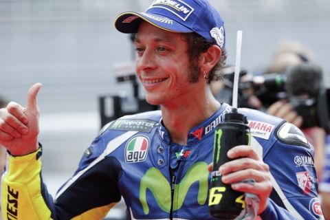 Yamaha MotoGP rider Valentino Rossi of Italy gives thumbs-up after becoming the second for the Malaysian Motorcycle Grand Prix in Sepang, Malaysia, Saturday, Oct. 29, 2016. (AP Photo/Vincent Thian)