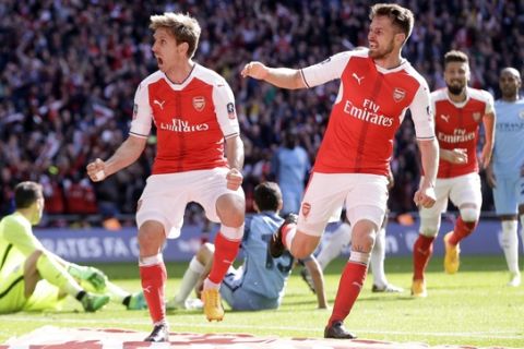 Arsenal's Nacho Monreal, left, celebrates his goal with Arsenal's Aaron Ramsey, right, during the English FA Cup semifinal soccer match between Arsenal and Manchester City at Wembley stadium in London, Sunday, April 23, 2017. (AP Photo/Alastair Grant)