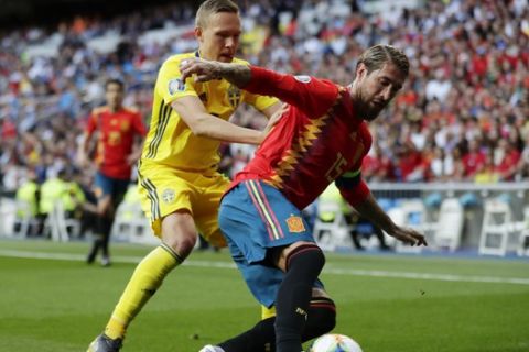 Sweden's Ludwig Augustinsson, left and Spain's Sergio Ramos challenges for the ball during the Euro 2020 Group F qualifying soccer match between Spain and Sweden at the Santiago Bernabeu stadium in Madrid, Monday June 10, 2019. (AP Photo/Manu Fernandez)