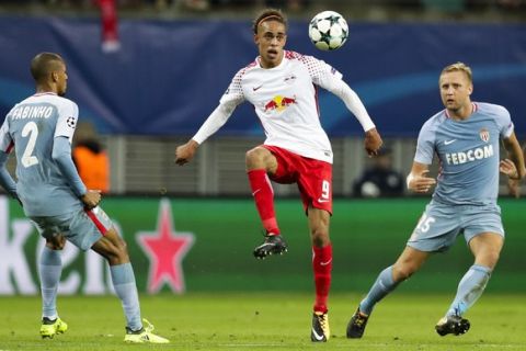 Leipzig's Yussuf Poulsen plays the ball between Monaco's Fabinho, left, and Monaco's Kamil Glik, right, during the Champions League Group G first leg soccer match between RB Leipzig and AS Monaco FC in Leipzig, Germany, Wednesday, Sept. 13, 2017. (AP Photo/Michael Sohn)