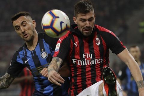 AC Milan's Alessio Romagnoli, right, clears the ball in front Inter Milan's Matias Vecino during a Serie A soccer match between AC Milan and Inter Milan, at the San Siro stadium in Milan, Italy, Sunday, March 17, 2019. (AP Photo/Luca Bruno)