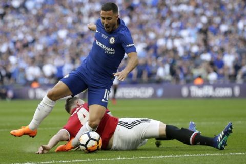 Manchester United's Phil Jones, on the ground, fouls Chelsea's Eden Hazard in the box to give away a penalty shot during the English FA Cup final soccer match between Chelsea and Manchester United at Wembley stadium in London, Saturday, May 19, 2018. (AP Photo/Tim Ireland)