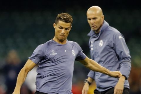 Real Madrid's Cristiano Ronaldo is watched by head coach Zinedine Zidane, right, during a training session at the Millennium Stadium in Cardiff, Wales Friday June 2, 2017. Real Madrid will play Juventus in the final of the Champions League soccer match in Cardiff on Saturday. (AP Photo/Frank Augstein)