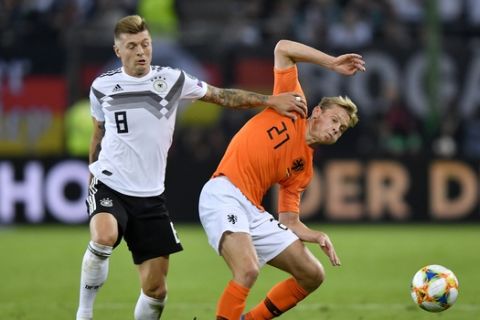Germany's Toni Kroos fights for the ball with Netherlands' Frenkie de Jong, right, during the Euro 2020 group C qualifying soccer match between Germany and the Netherlands at the Volksparkstadion in Hamburg, Germany, Friday, Sept. 6, 2019. (AP Photo/Martin Meissner)
