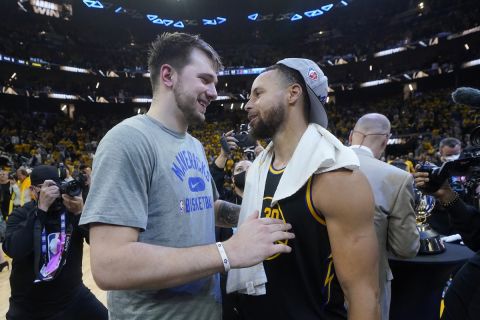 Dallas Mavericks guard Luka Doncic, left, greets Golden State Warriors guard Stephen Curry after the Warriors defeated the Dallas Mavericks in Game 5 of the NBA basketball playoffs Western Conference finals in San Francisco, Thursday, May 26, 2022. (AP Photo/Jeff Chiu)