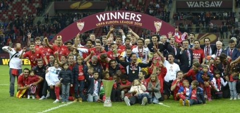 Sevilla's team celebrate with the trophy after the UEFA Europa League final football match between FC Dnipro Dnipropetrovsk and Sevilla FC at the Narodowy stadium in Warsaw, Poland on May 27, 2015. Sevilla FC won 2-3.    AFP PHOTO / JORGE GUERRERO        (Photo credit should read Jorge Guerrero/AFP/Getty Images)