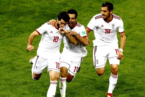 Iran's Karim Ansarifard, left, celebrates with his teammates after scoring his side's first goal during the group B match between Iran and Portugal at the 2018 soccer World Cup at the Mordovia Arena in Saransk, Russia, Monday, June 25, 2018. (AP Photo/Darko Bandic)