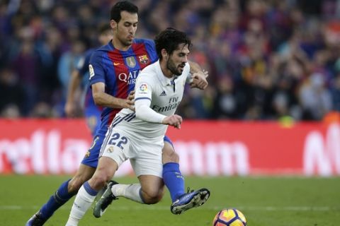 Real Madrid's Isco fights for the ball with Barcelona's Sergio Busquets, left, during the Spanish La Liga soccer match between FC Barcelona and Real Madrid at the Camp Nou in Barcelona, Spain, Saturday, Dec. 3, 2016. (AP Photo/Manu Fernandez)