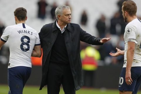 Tottenham's manager Jose Mourinho, center, talks with Tottenham's Harry Winks, left, and Harry Kane at the end of the English Premier League soccer match between West Ham and Tottenham, at London stadium, in London, Saturday, Nov. 23, 2019.(AP Photo/Frank Augstein)